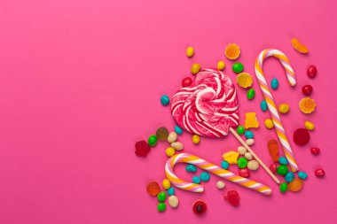 Pembe bir arka plan üzerinde renkli lolipop