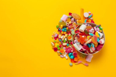 sarı arka plan üzerinde renkli şekerler