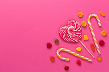 Pembe bir arka plan üzerinde renkli lolipop