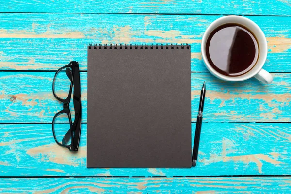 木製の机の上のノートとコーヒーのカップ — ストック写真