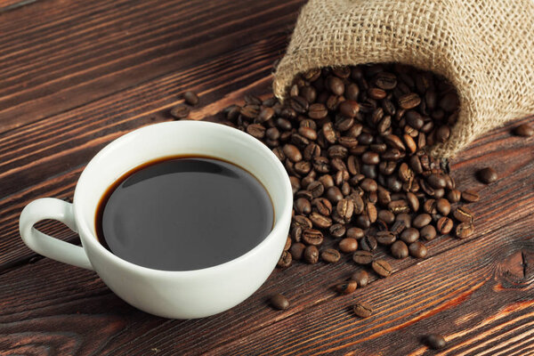 Coffee cup and coffee beans on wooden background