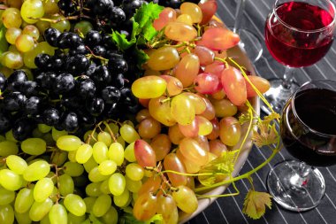 Beyaz üzüm dalları ile şarap. Ahşap bir masaya.