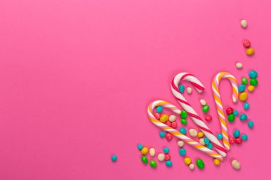 Pembe bir arka plan üzerinde renkli lolipop