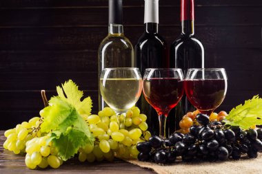 Şarap şişesi ve ahşap masa üzüm