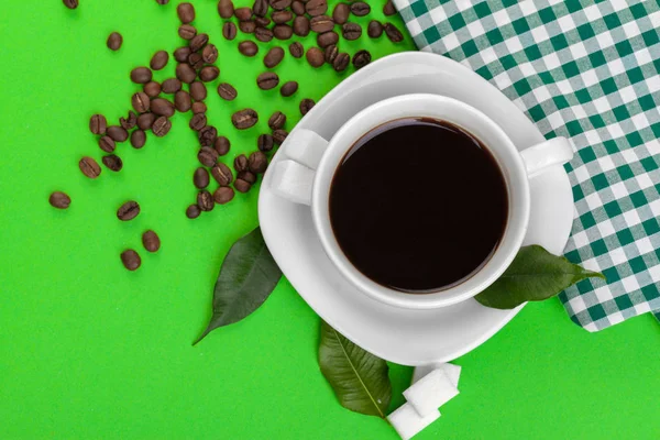 Cup of coffee on green background.