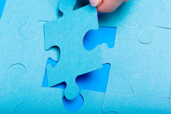 close up of hand holding Puzzle piece on colorful background 