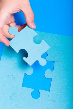 Bulmaca parçası renkli arka plan üzerinde tutan el yakın çekim 