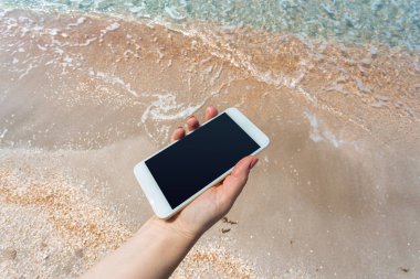 Güzel kadın eli beach adlı akıllı telefon kullanma