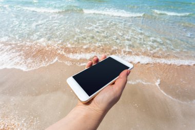Güzel kadın eli beach adlı akıllı telefon kullanma