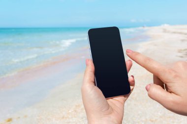 Güzel kadın eli beach adlı akıllı telefon kullanma