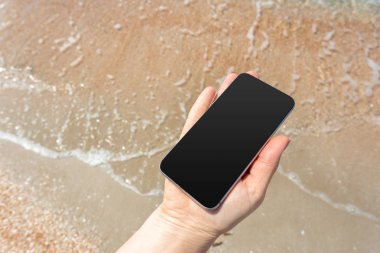 Güzel kadın eli beach adlı akıllı telefon kullanma