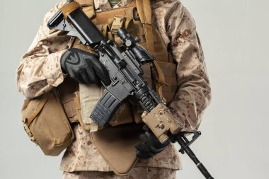 Kamuflajlı asker elinde tüfekle