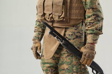 Kamuflajlı asker elinde tüfekle