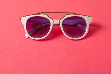 Düz yatıyordu. Üstten Görünüm. Pastel arka plan üzerinde moda güneş gözlüğü