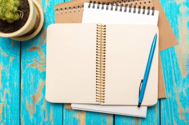 Üstten görünüm çalışma alanıyla boş defter ve kalem ahşap masa arka plan üzerinde