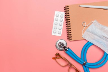 pastel pembe bir arka plan üzerinde tıbbi ekipman üstten görünüm.