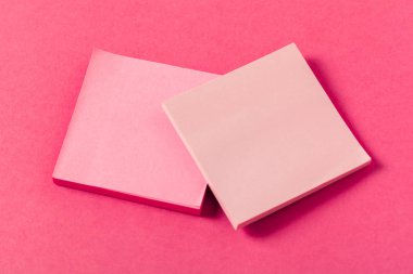 Pembe renkli bir arka plan üzerinde boş kağıt parçaları