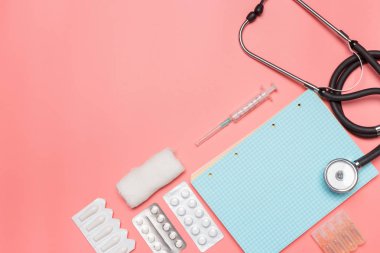 pastel pembe bir arka plan üzerinde tıbbi ekipman üstten görünüm.