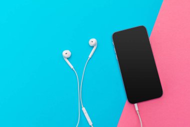 Kulaklık ve renkli arka plan üzerinde cep telefonu ile fotoğraf çalışma masası yaratıcı düz göklere 