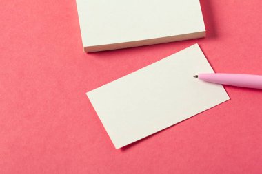 Pembe renkli bir arka plan üzerinde boş kağıt parçaları