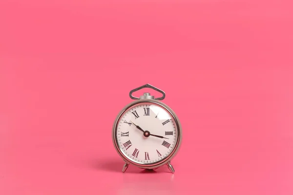 关闭在粉红色的背景上的闹钟 — 图库照片