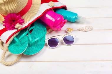 Beachwear ve aksesuar beyaz ahşap zemin üzerinde