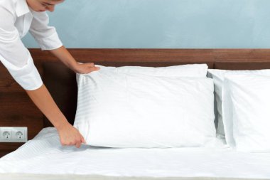 Genç hizmetçi otel odasında yatak yapma