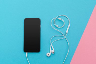 Kulaklık ve renkli arka plan üzerinde cep telefonu ile fotoğraf çalışma masası yaratıcı düz göklere 