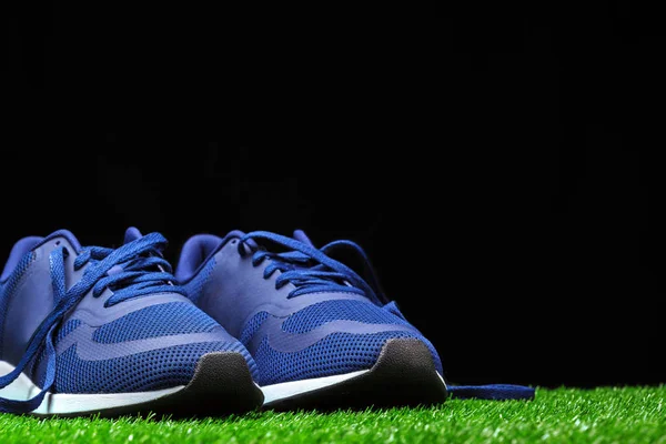 Spor Ayakkabı Siyah Arka Plan Karşı Çimenlerin Üzerinde Kapat — Stok fotoğraf