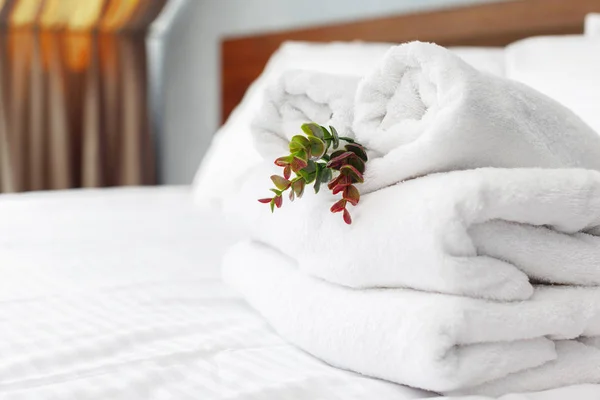close up of towels and flower on bed in hotel room