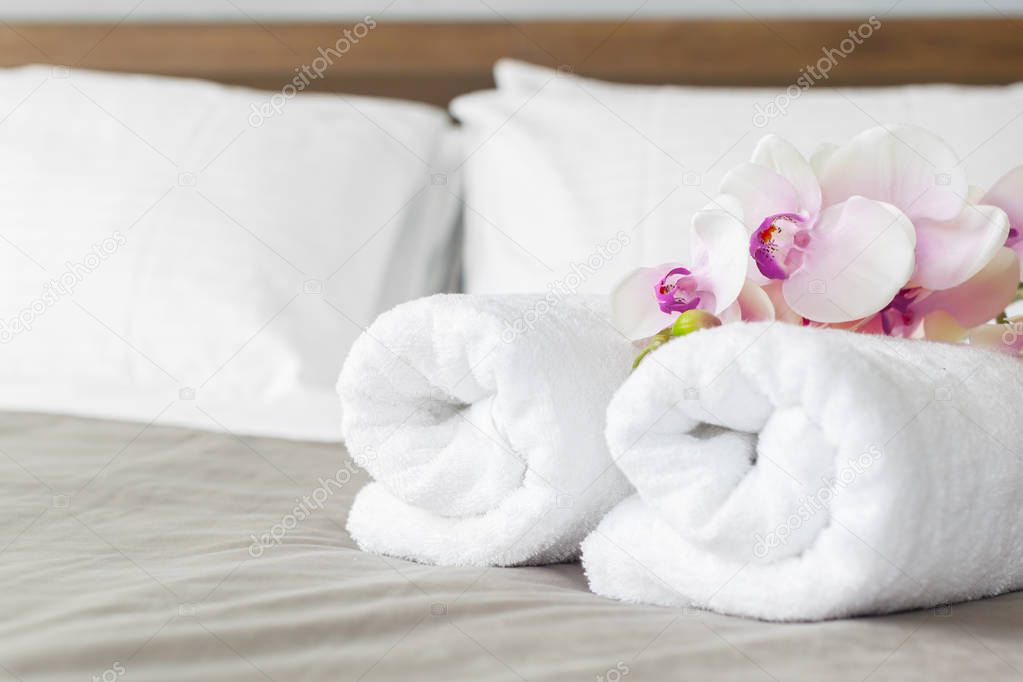close up of towels and flowers on bed in hotel room
