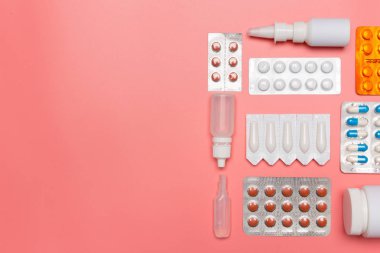 Pembe arka planda ilaç hapları. Üst görünüm