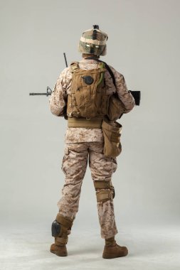 Kamuflajlı asker elinde tüfekle