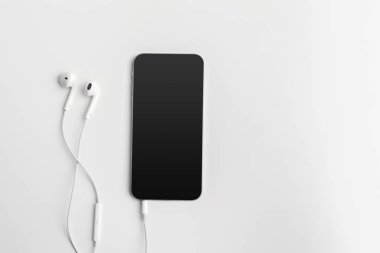 Kulaklık ve beyaz arka plan üzerinde cep telefonu ile fotoğraf çalışma masası yaratıcı düz göklere 