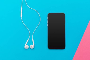 Kulaklık ve renkli arka plan üzerinde cep telefonu ile fotoğraf çalışma masası yaratıcı düz göklere 