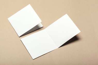 Bej renkli bir arka plan üzerinde boş kağıt parçaları için alay et