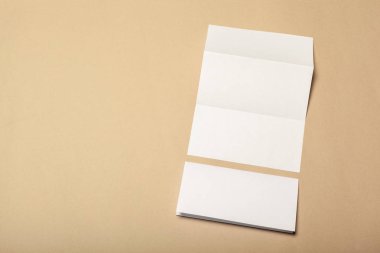Bej renkli bir arka plan üzerinde boş kağıt parçaları için alay et