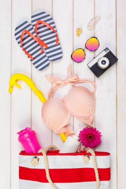 Beachwear ve aksesuar beyaz ahşap zemin üzerinde