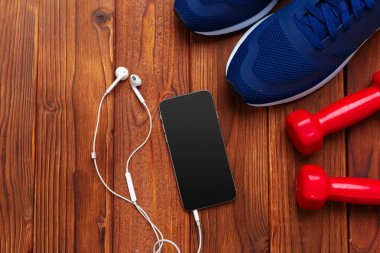 spor ayakkabı ve ahşap arka plan üzerinde halter ile Fitness kavramının yakın çekim 