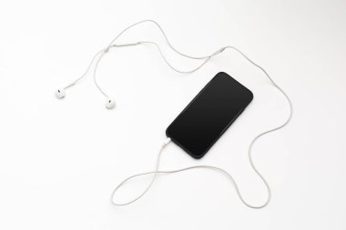 Kulaklık ve beyaz arka plan üzerinde cep telefonu ile fotoğraf çalışma masası yaratıcı düz göklere 