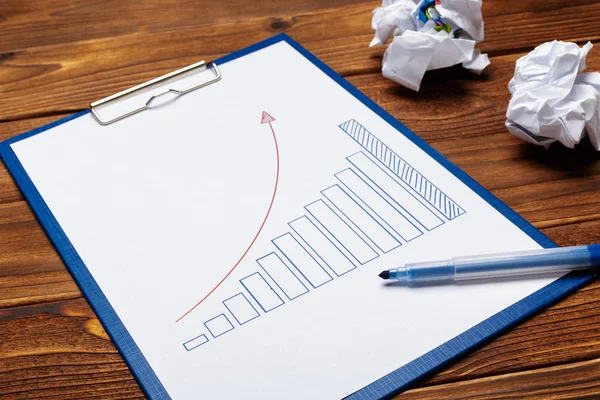 Top view of business paper charts or graphs on wooden table