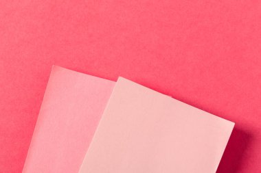 Pembe renkli arka plan üzerinde boş kağıt parçaları
