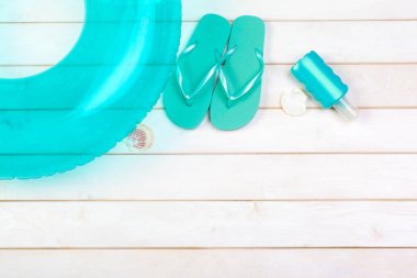 Beachwear ve aksesuar beyaz ahşap zemin üzerinde