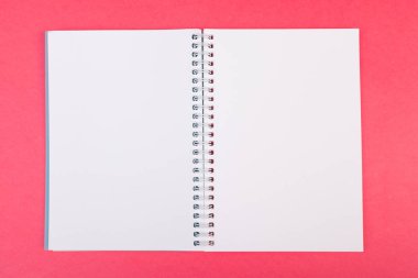 Boş açık defter üzerinde parlak pembe arka plan üstten görünüm