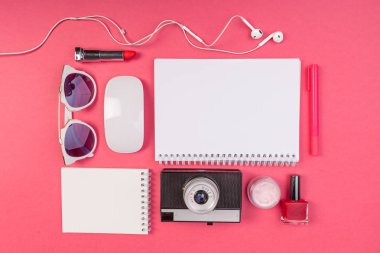 Kompozisyon alay kadar not defteri, kamera, kulaklık ve aksesuarları üzerinde pembe bir arka plan üstten görünüm