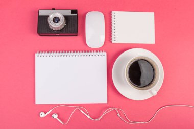 Kompozisyon alay kadar not defteri, kamera, kulaklık ve aksesuarları üzerinde pembe bir arka plan üstten görünüm