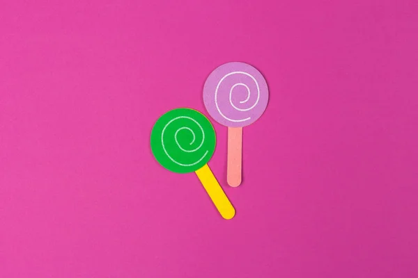 党的背景的纸糖果 纸棒棒糖在粉红色的背景上 顶部视图与复制空间 — 图库照片