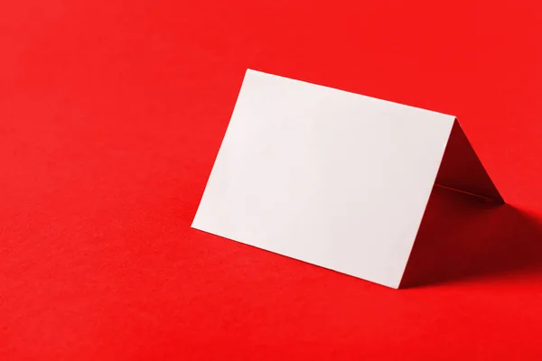 Blank white business card on red background