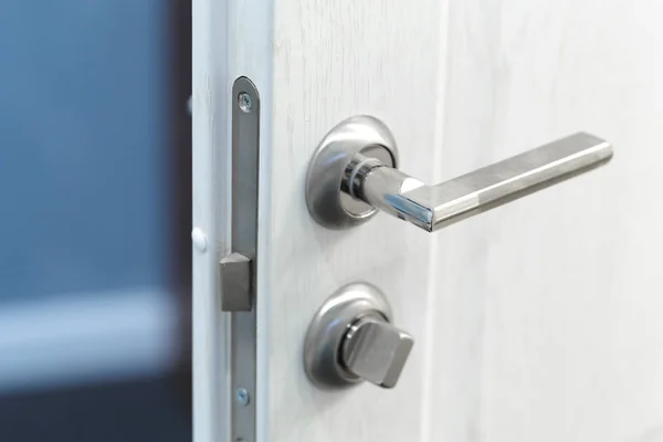 Detail of a metallic knob on white door horizontal