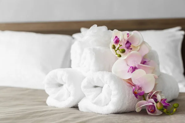 close up of towels and flowers on bed in hotel room
